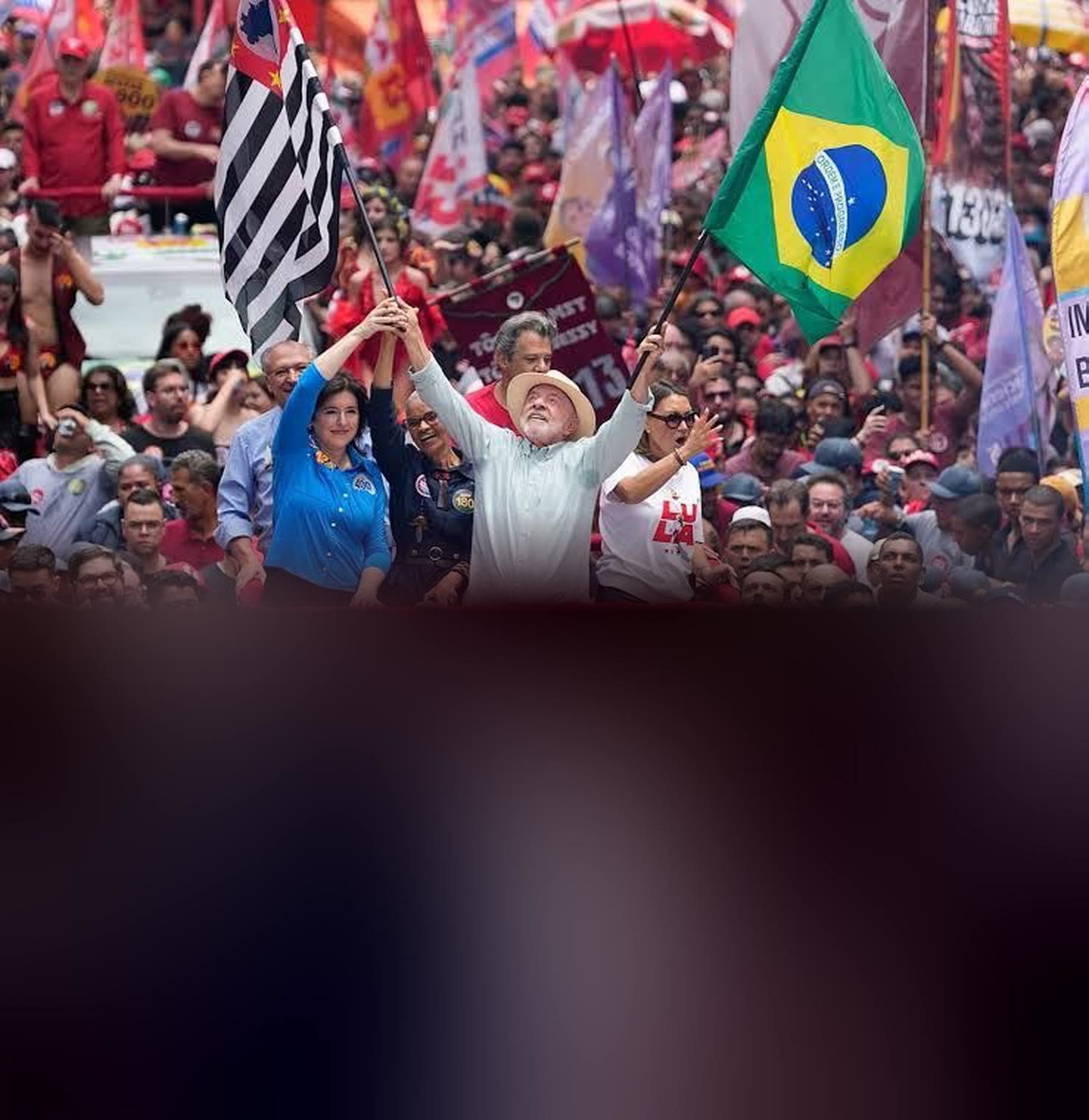 Lula e i candidati alzano le braccia tra la folla con le bandiere del Brasile